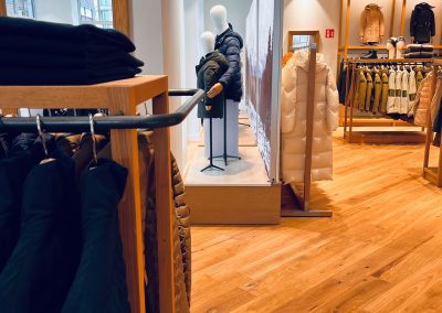 Shopfitting Woolrich - pohled na výlohu s podstavci, na kterých jsou figuríny s oblečením